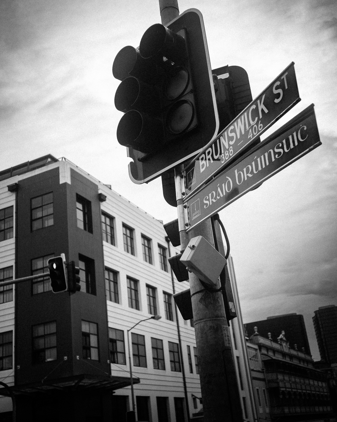 Black and white Brunswick Street sign and traffic lights outside the building